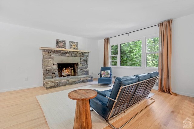 living room featuring hardwood / wood-style flooring and a stone fireplace