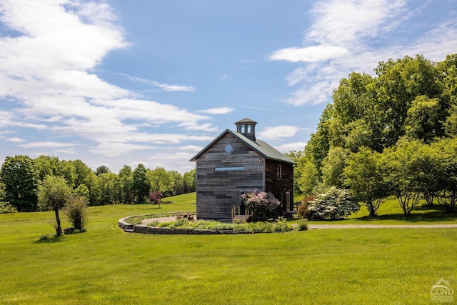 view of community featuring an outdoor structure, a lawn, and a barn