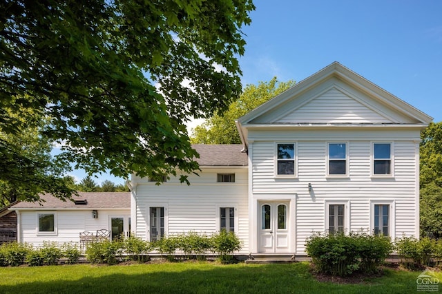 rear view of property featuring a yard