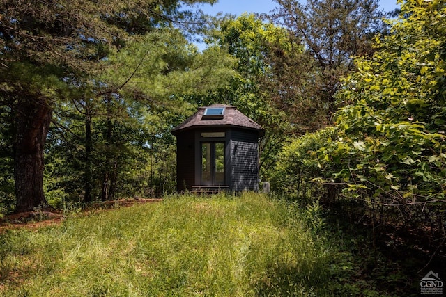 view of outbuilding with an outdoor structure and a forest view