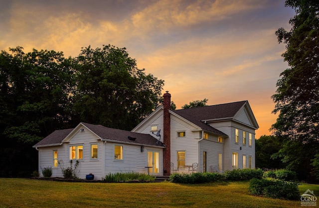 view of front of house with a chimney and a front lawn