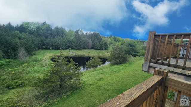 view of yard with a deck with water view