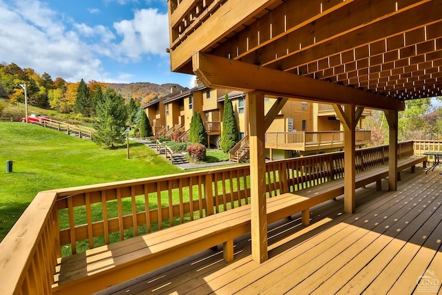 wooden deck with a lawn and a mountain view