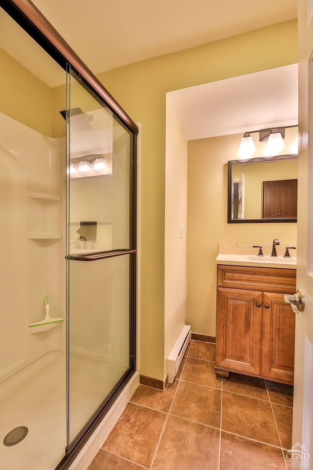 bathroom featuring tile patterned flooring, vanity, a shower with door, and a baseboard radiator