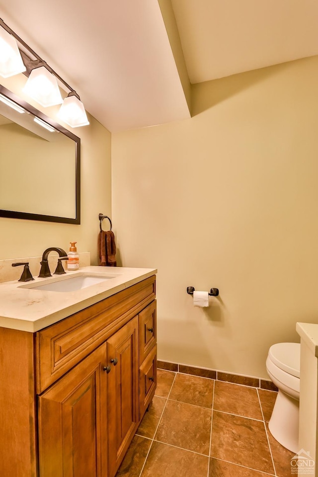 bathroom featuring tile patterned flooring, vanity, and toilet