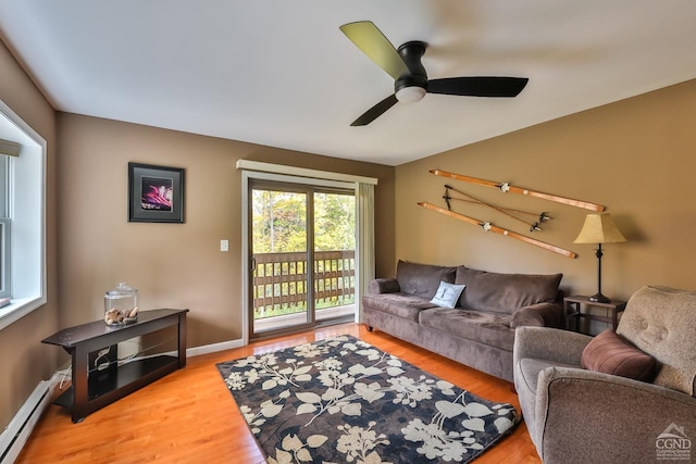 living room featuring a baseboard radiator, light hardwood / wood-style flooring, and ceiling fan