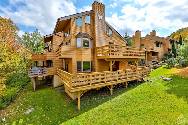 rear view of property with a yard and a deck