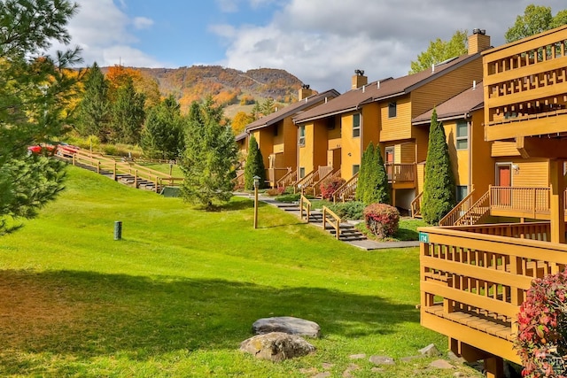 view of community with a mountain view and a lawn