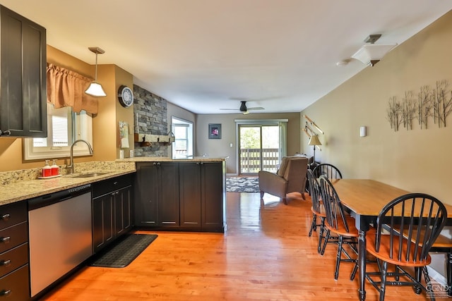 kitchen featuring light stone countertops, light wood-type flooring, ceiling fan, decorative light fixtures, and dishwasher