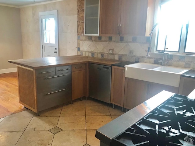 kitchen with dishwasher, ornamental molding, plenty of natural light, and light wood-type flooring