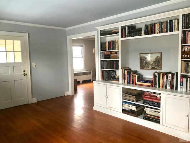 interior space with dark hardwood / wood-style flooring, radiator heating unit, and ornamental molding