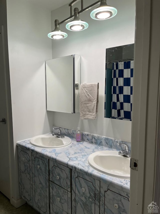 bathroom featuring a shower with curtain, double vanity, and a sink
