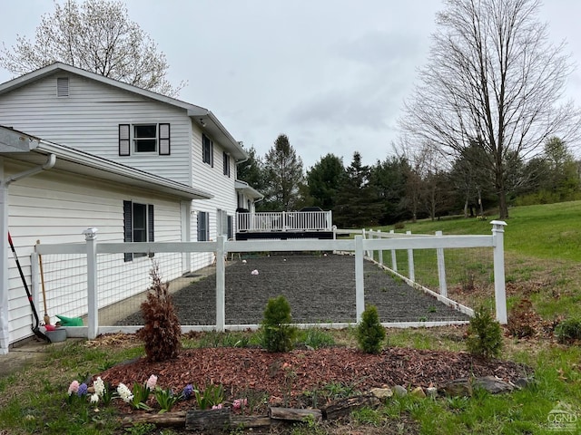 view of side of property with a deck and fence
