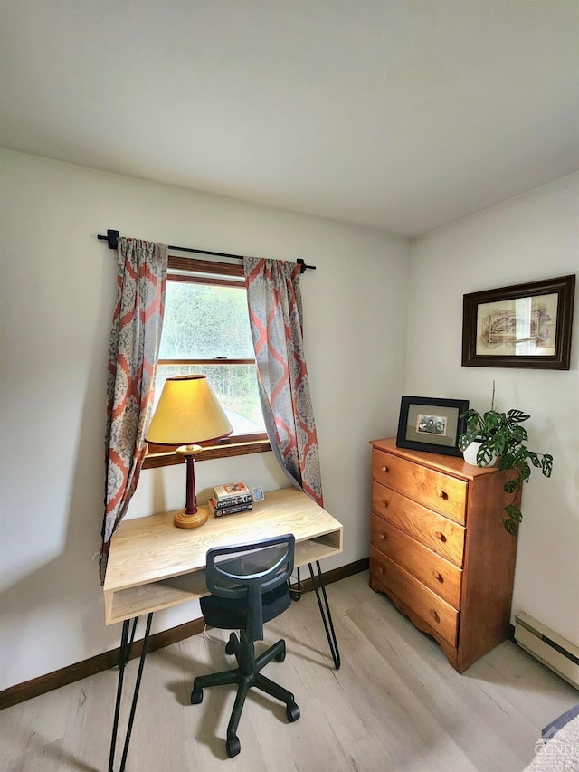 home office with baseboard heating, baseboards, and light wood-style flooring