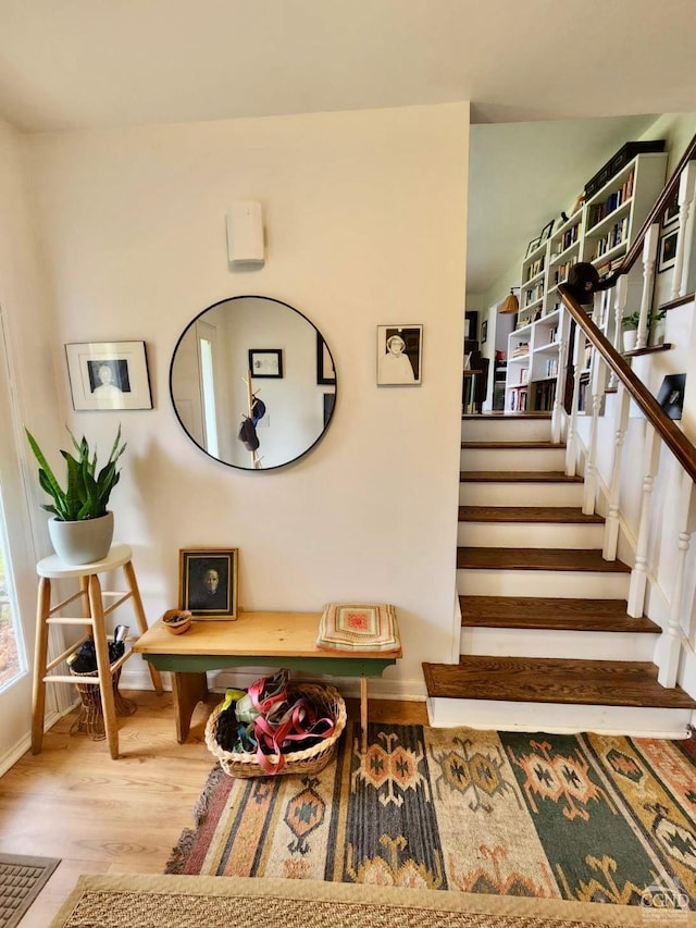 stairs with wood finished floors and baseboards