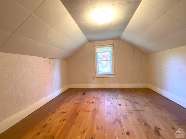 bonus room with wood-type flooring and lofted ceiling