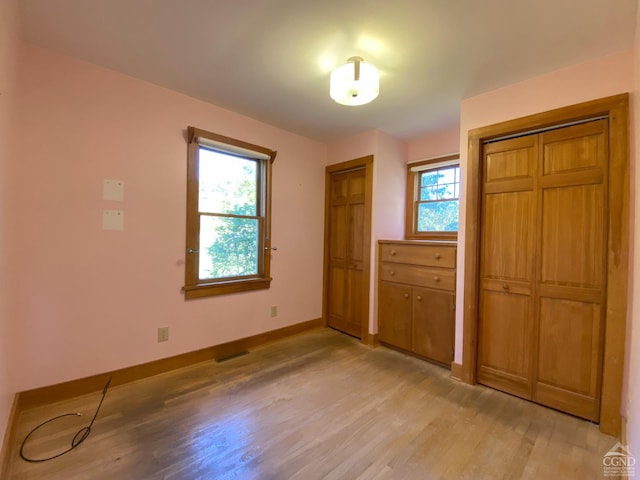 unfurnished bedroom featuring light hardwood / wood-style flooring and multiple windows