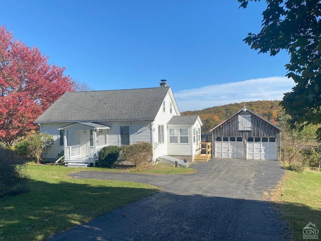 view of front facade featuring a front yard, an outdoor structure, and a garage