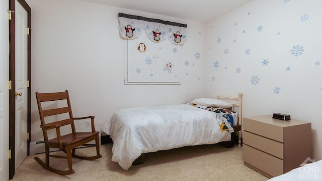 bedroom with baseboard heating and light carpet