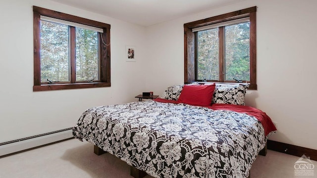 bedroom with carpet flooring, baseboard heating, and multiple windows