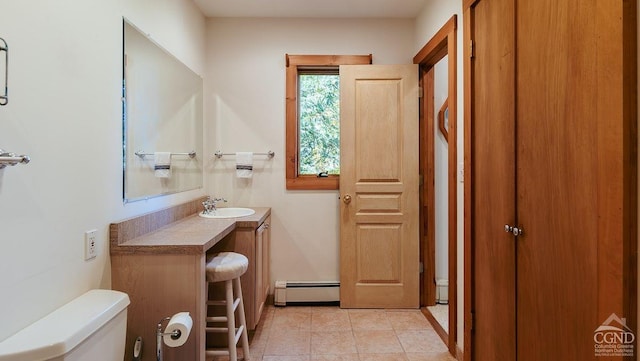 bathroom with tile patterned floors, vanity, toilet, and a baseboard radiator