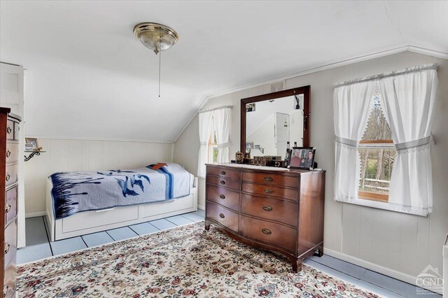 bedroom with baseboards, tile patterned flooring, and vaulted ceiling