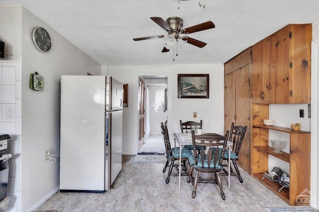 dining room with a ceiling fan and baseboards