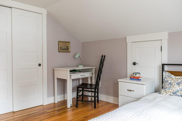 bedroom with light wood-type flooring and lofted ceiling