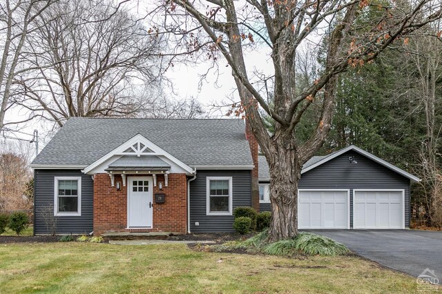 view of front of house featuring an outdoor structure, a front yard, and a garage