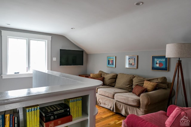 living room featuring wood-type flooring and vaulted ceiling