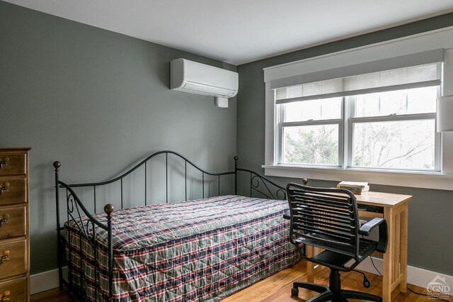 bedroom with wood-type flooring and a wall mounted air conditioner