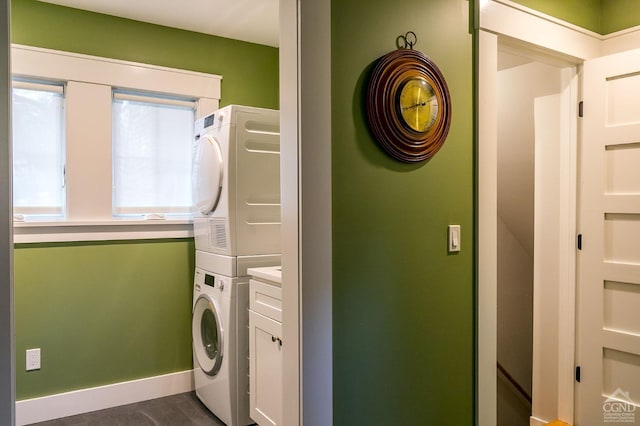 laundry room with cabinets and stacked washer and dryer