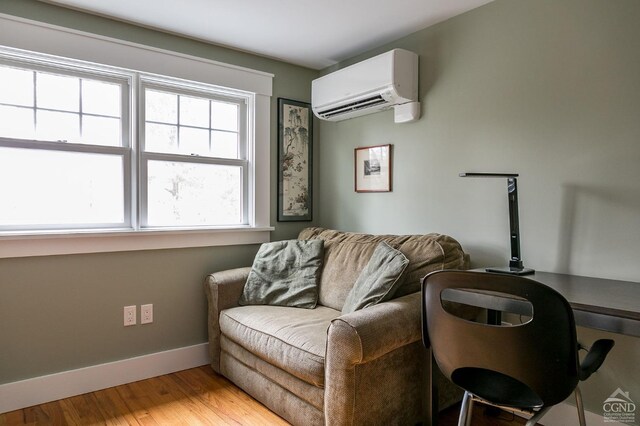 sitting room featuring light hardwood / wood-style floors and a wall mounted AC