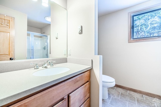 bathroom featuring vanity, toilet, and a shower with shower door