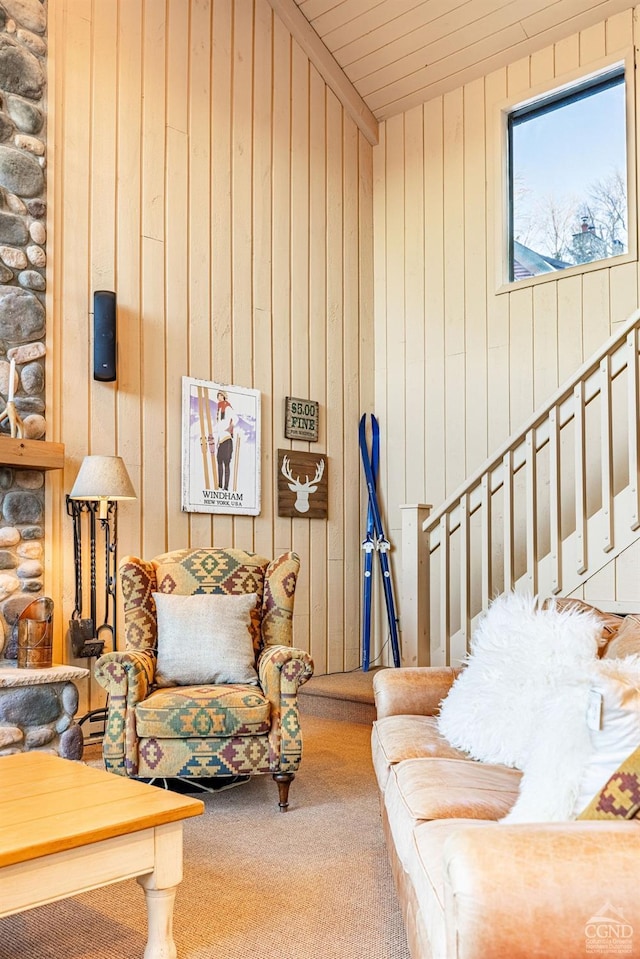 carpeted living room with wooden walls