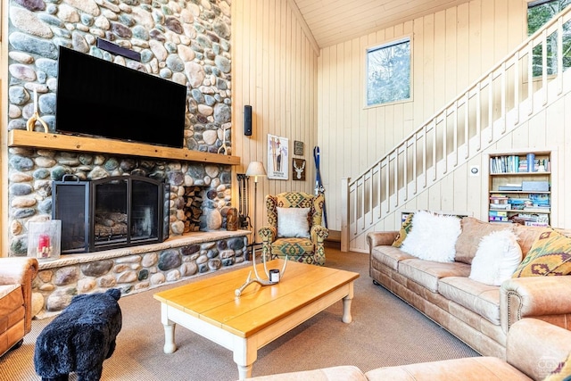 carpeted living room featuring wooden walls, a fireplace, and high vaulted ceiling