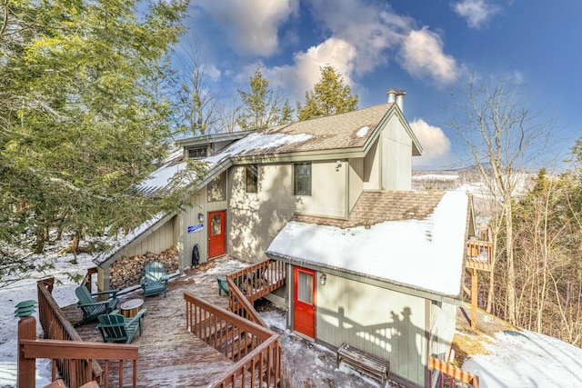 snow covered property with a wooden deck