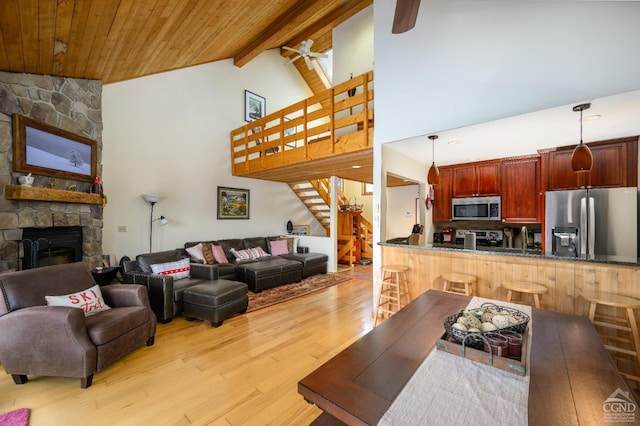 living room with beam ceiling, light hardwood / wood-style flooring, wooden ceiling, ceiling fan, and a fireplace