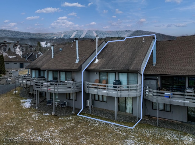 rear view of house featuring a deck with mountain view