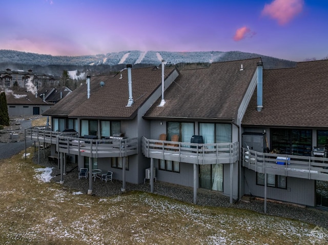 back house at dusk with a deck