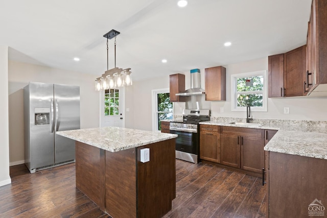 kitchen featuring dark hardwood / wood-style flooring, wall chimney exhaust hood, stainless steel appliances, sink, and a center island