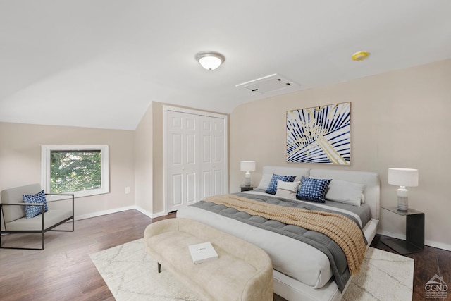 bedroom featuring vaulted ceiling, a closet, and dark hardwood / wood-style floors