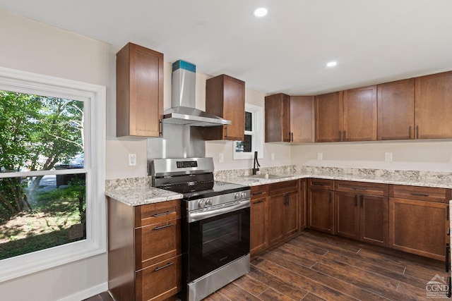 kitchen with dark wood-type flooring, wall chimney range hood, sink, stainless steel range, and light stone counters