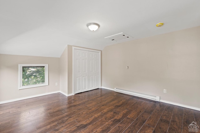 spare room featuring dark hardwood / wood-style floors, lofted ceiling, and a baseboard radiator