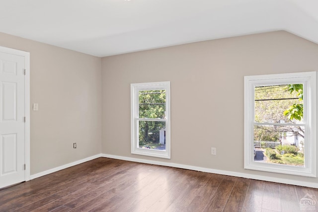 spare room featuring dark hardwood / wood-style floors and lofted ceiling