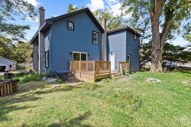 rear view of house featuring a lawn and a deck