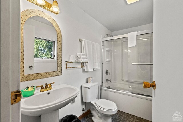 full bathroom featuring toilet, sink, and combined bath / shower with glass door