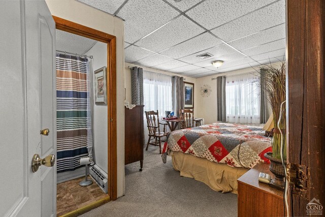 bedroom with carpet flooring and a paneled ceiling