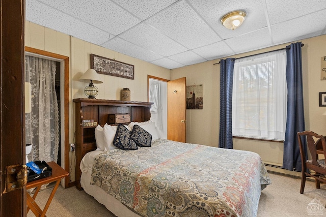 bedroom featuring a paneled ceiling, light colored carpet, and a closet