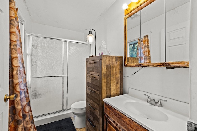 bathroom with toilet, vanity, and walk in shower